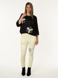 Chandail noir avec deux fleurs décoratives