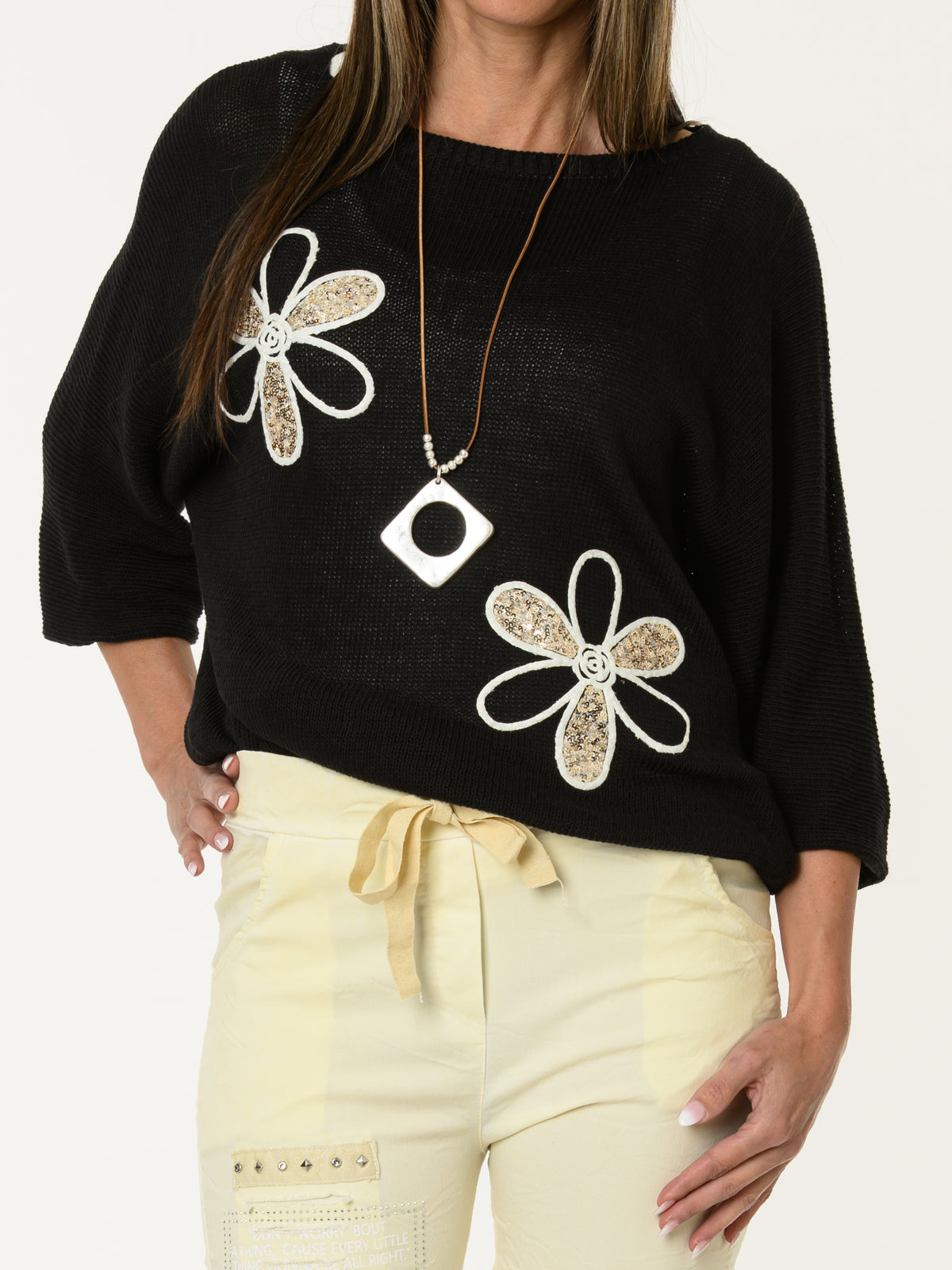 Chandail noir avec deux fleurs décoratives