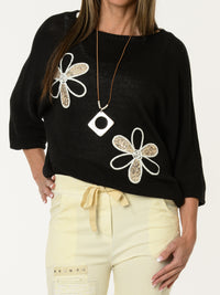 Chandail noir avec deux fleurs décoratives