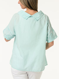 Blouse aqua à col roulé et fleurs brodées