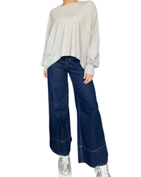 Chandail beige uni à manche longue pour femme avec sneakers. 
