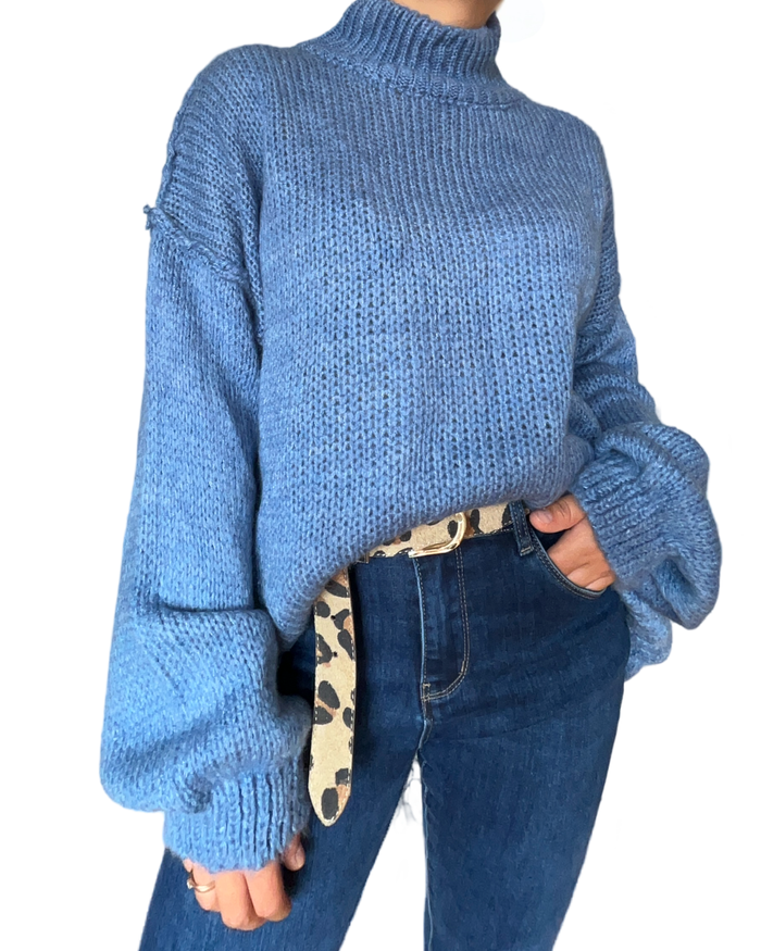 Chandail bleu en tricot à manche longue pour femme avec ceinture animal print et jeans.