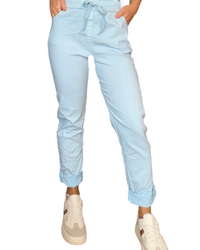 Pantalon bleu ciel à taille élastique avec cordon pour femme avec sneakers.