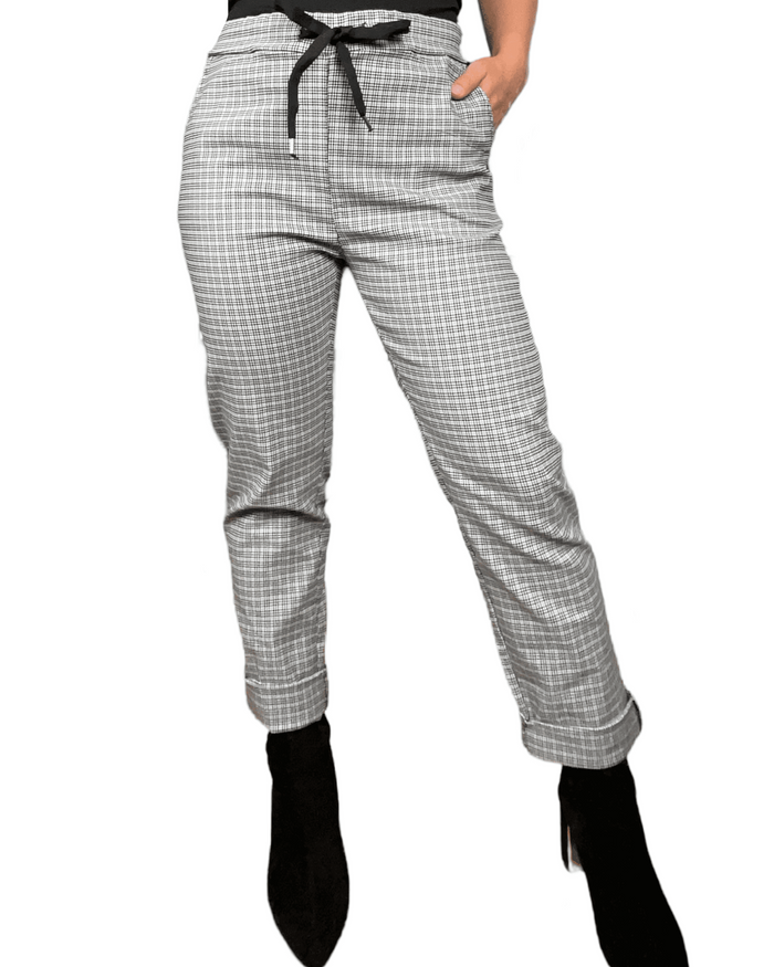 Pantalon blanc à carreaux noirs et gris pour femme.