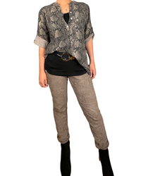 Blouse brune pour femme avec imprimé de peau de serpent avec ceinture noir et pantalon brun.