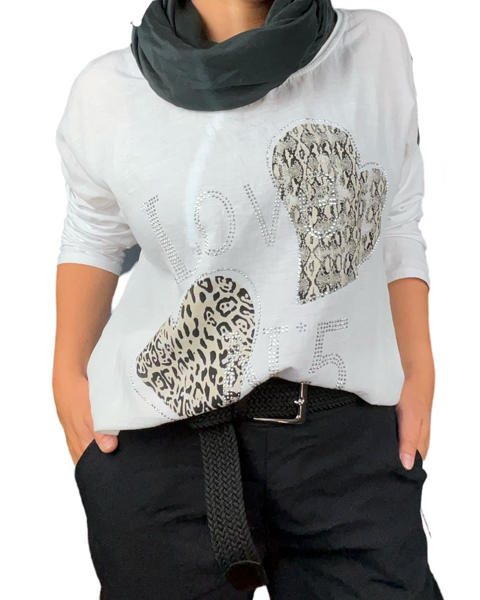 Chandail blanc pour femme avec imprimé de cœurs animal print avec foulard noir et ceinture noire.